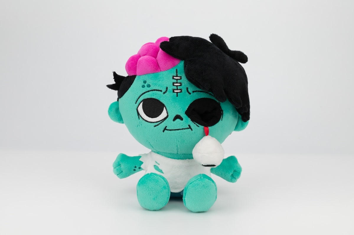 Our turquoise zombie plushie, with a pink plush brain, black hair and a dangling eyeball